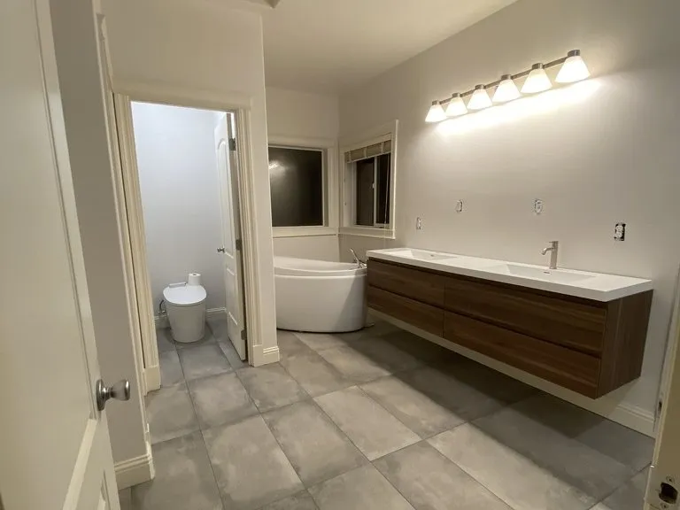 A bathroom with a freestanding tub and a floating timber vanity