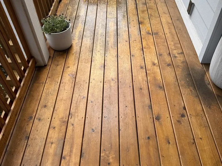 A finished cedar deck with a potted plant against the rail