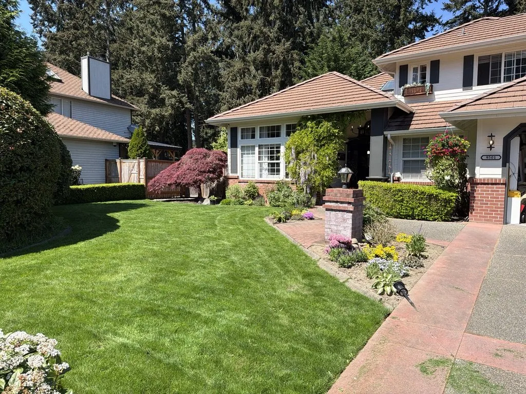 A repainted home exterior with a brick path and lawn