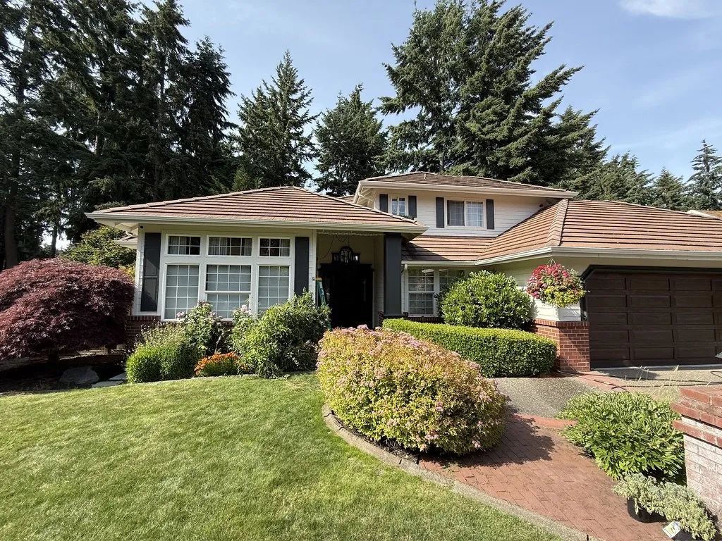 A repainted home exterior framed by mature planting