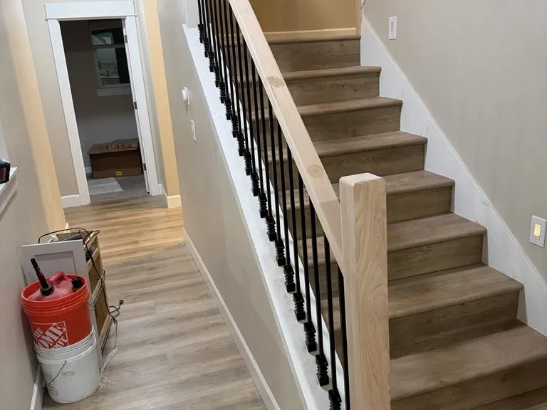 A staircase with black balusters, part-way through finishing