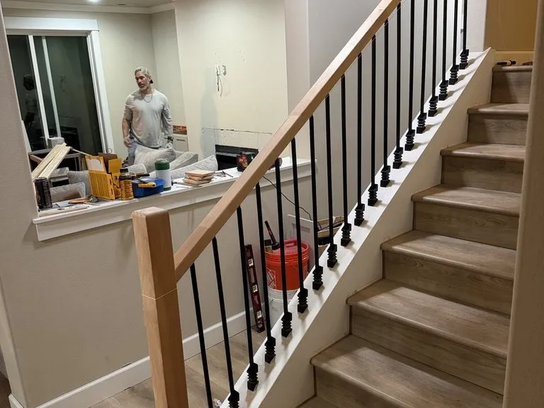 A finished stair and landing, with the crew still working beyond