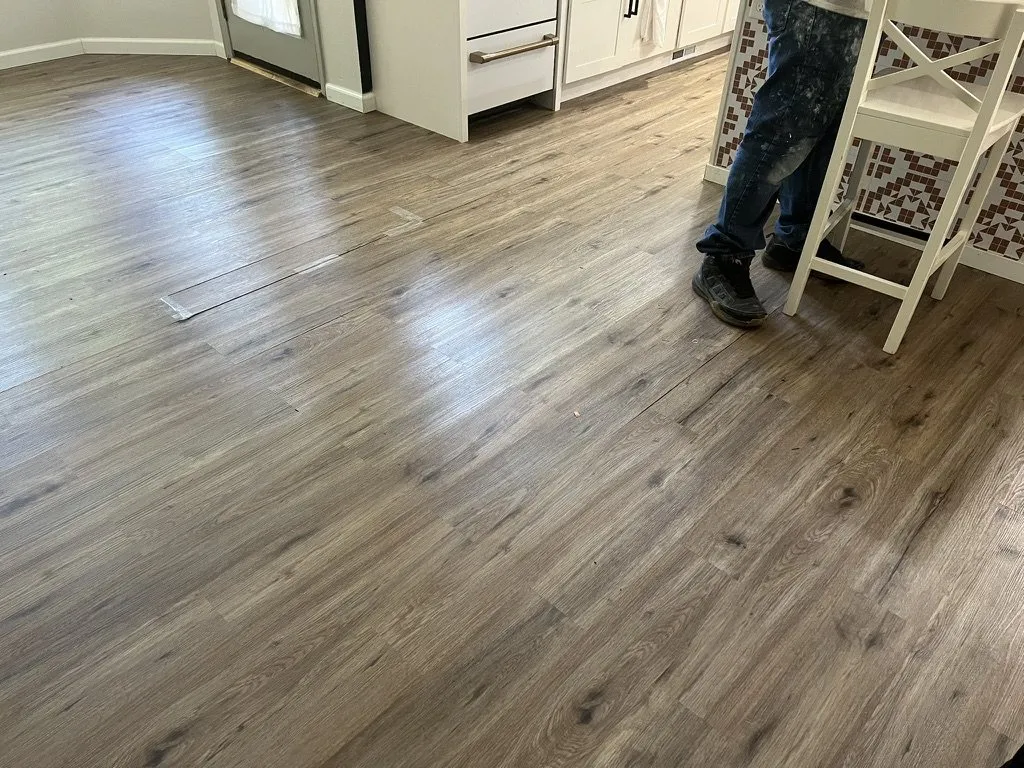 An installer working across a newly laid plank floor