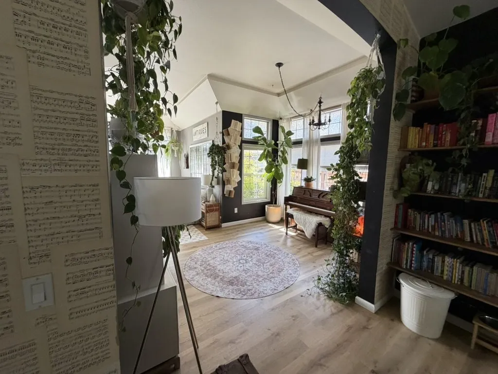 A wide living room with new flooring, built-in shelving and plants