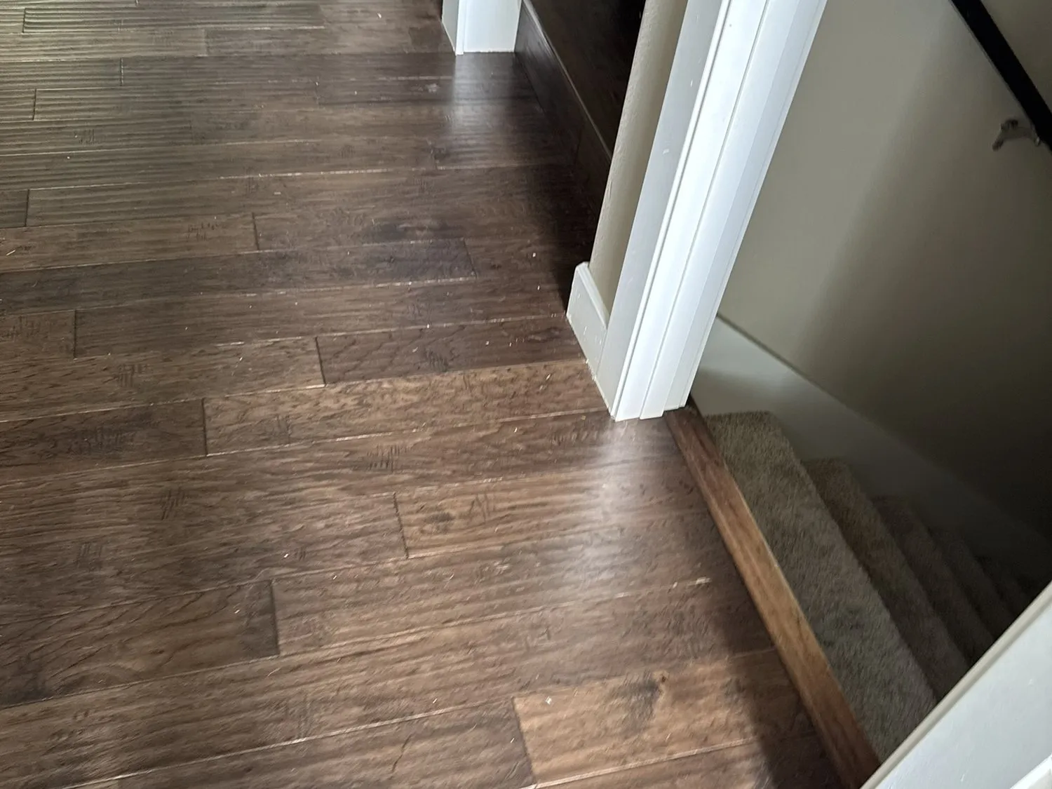 New dark plank flooring meeting the base of the stair