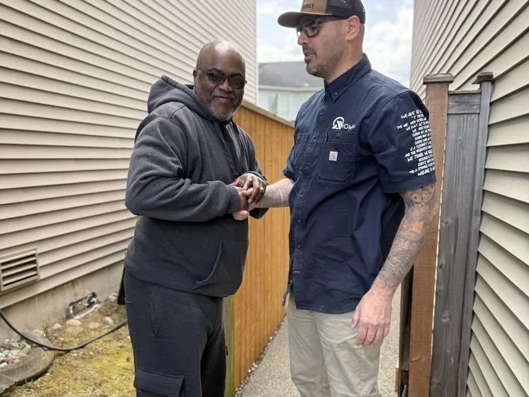 An All Home HX crew member shaking hands with a neighbour after the work