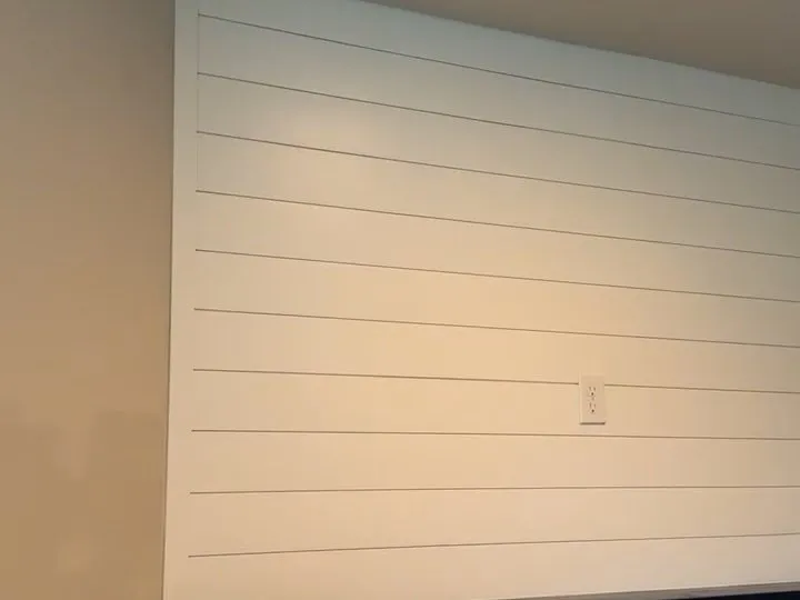 The shiplap wall and mantel meeting the corner of the room