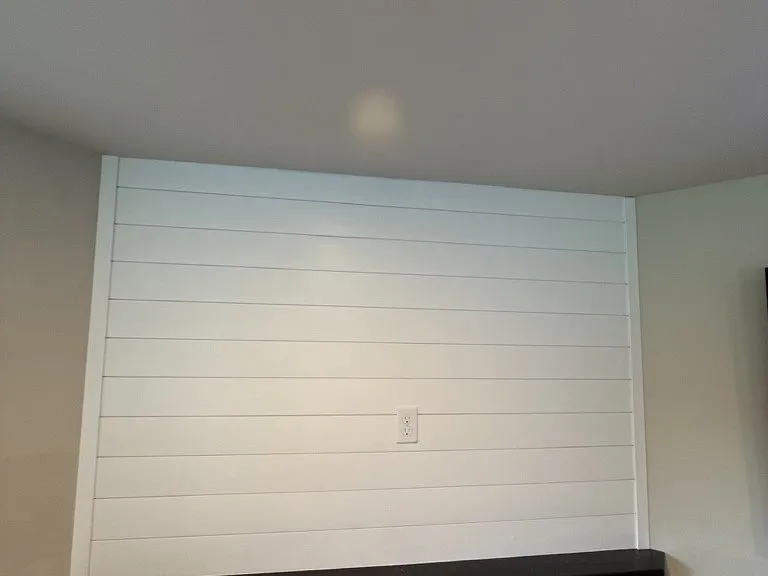 The finished shiplap wall and dark timber mantel