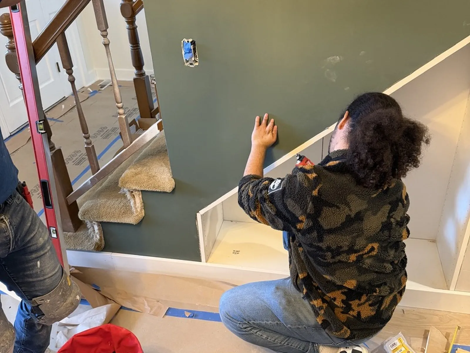 An All Home HX crew member building the board-and-batten panelling on the stair wall