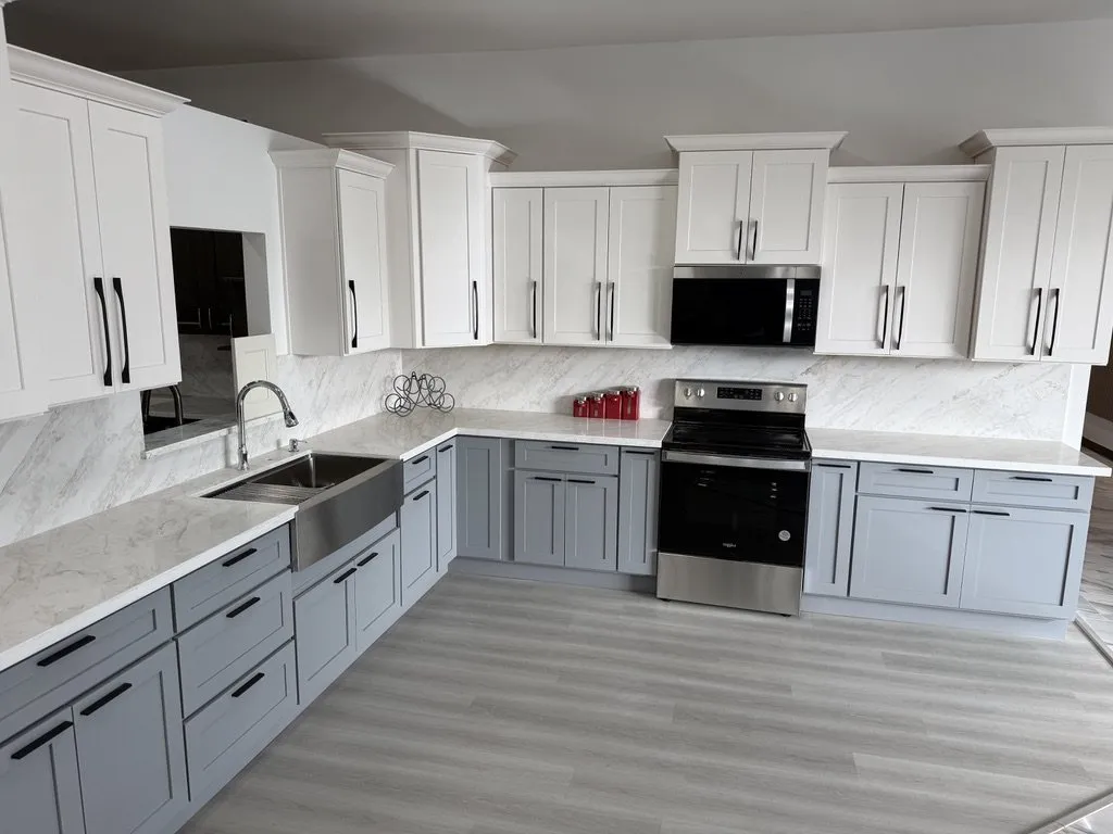 A two-tone kitchen with white uppers, grey base cabinets and a stainless range