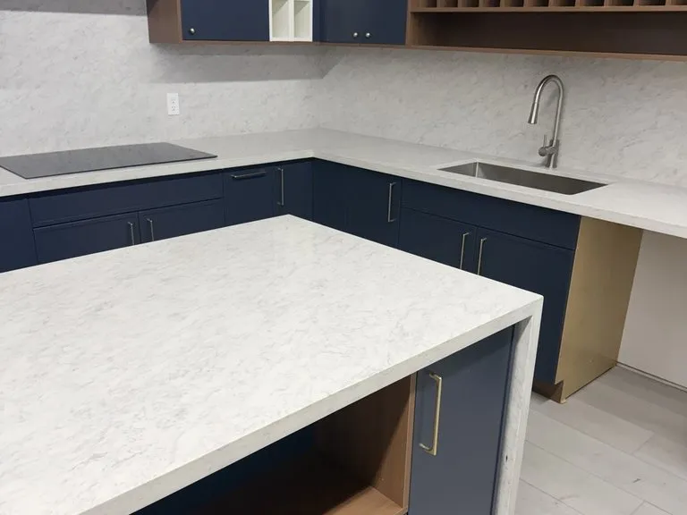 A navy island with a white waterfall counter