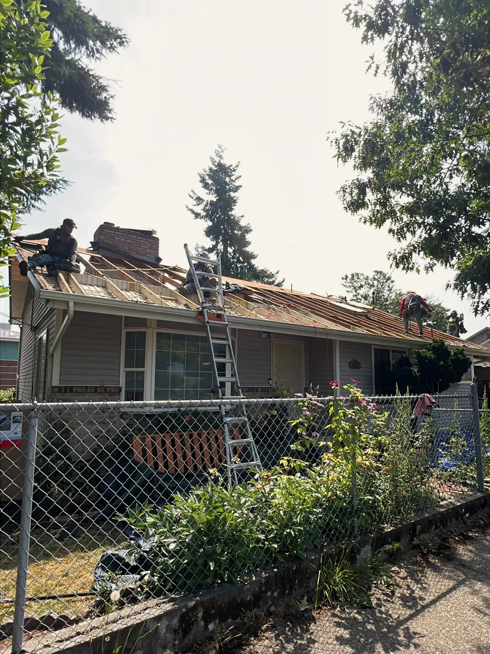 An AHX crew stripping the old roof off a single-storey home during a full tear-off