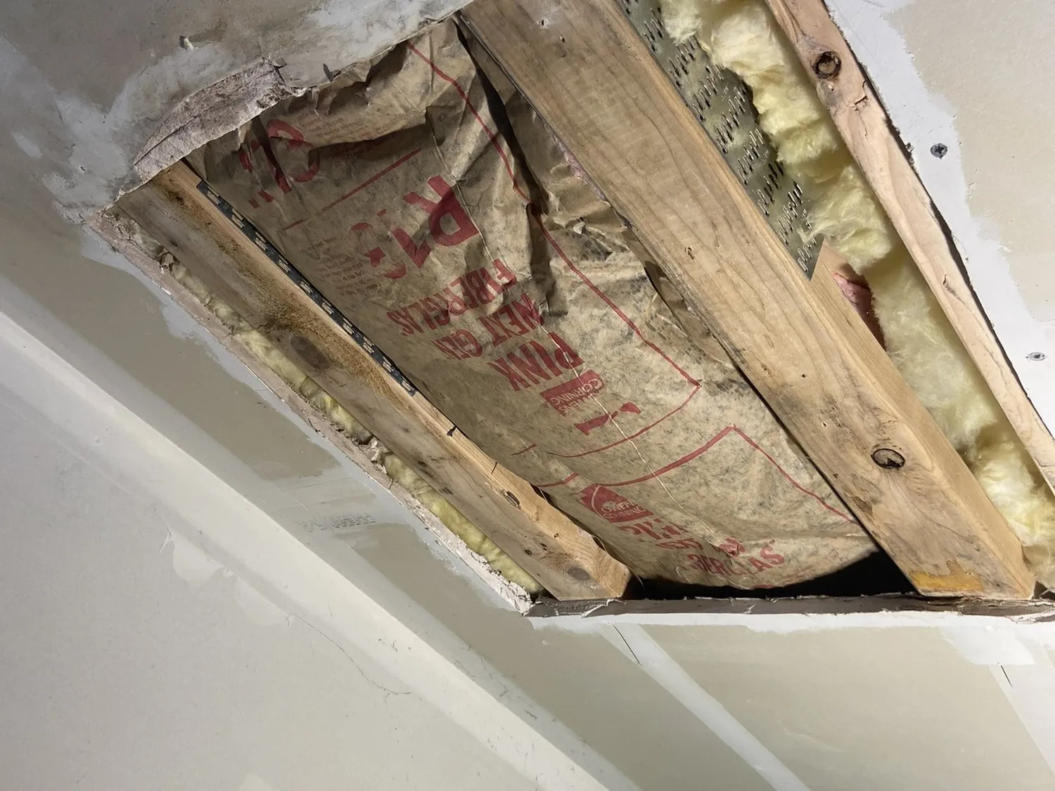 A ceiling cut open to reach damaged framing