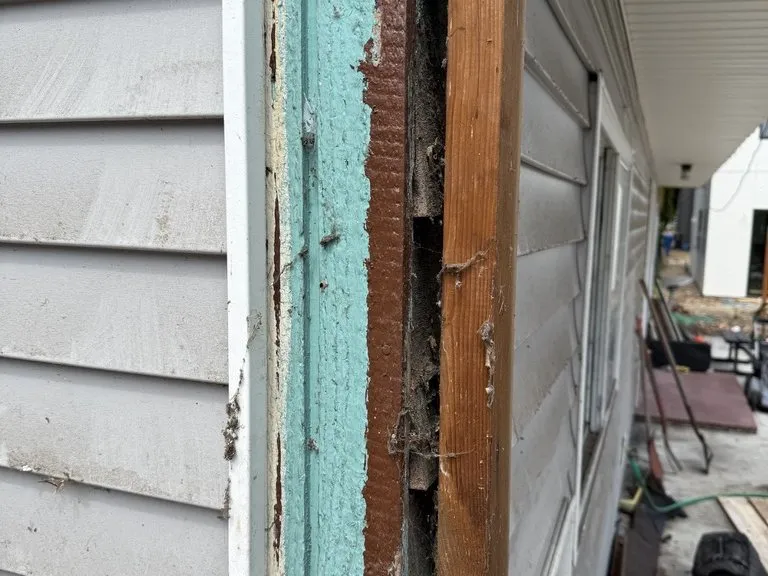 Rot exposed at a door jamb with the siding removed