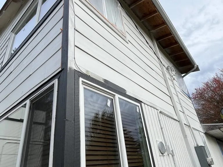 New siding and trim fitted around a bay window