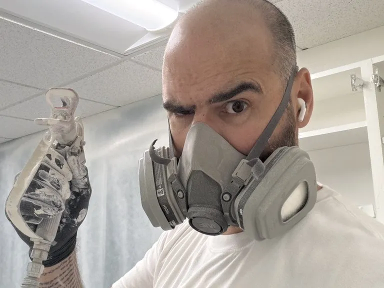 A crew member in a respirator during an exterior spray