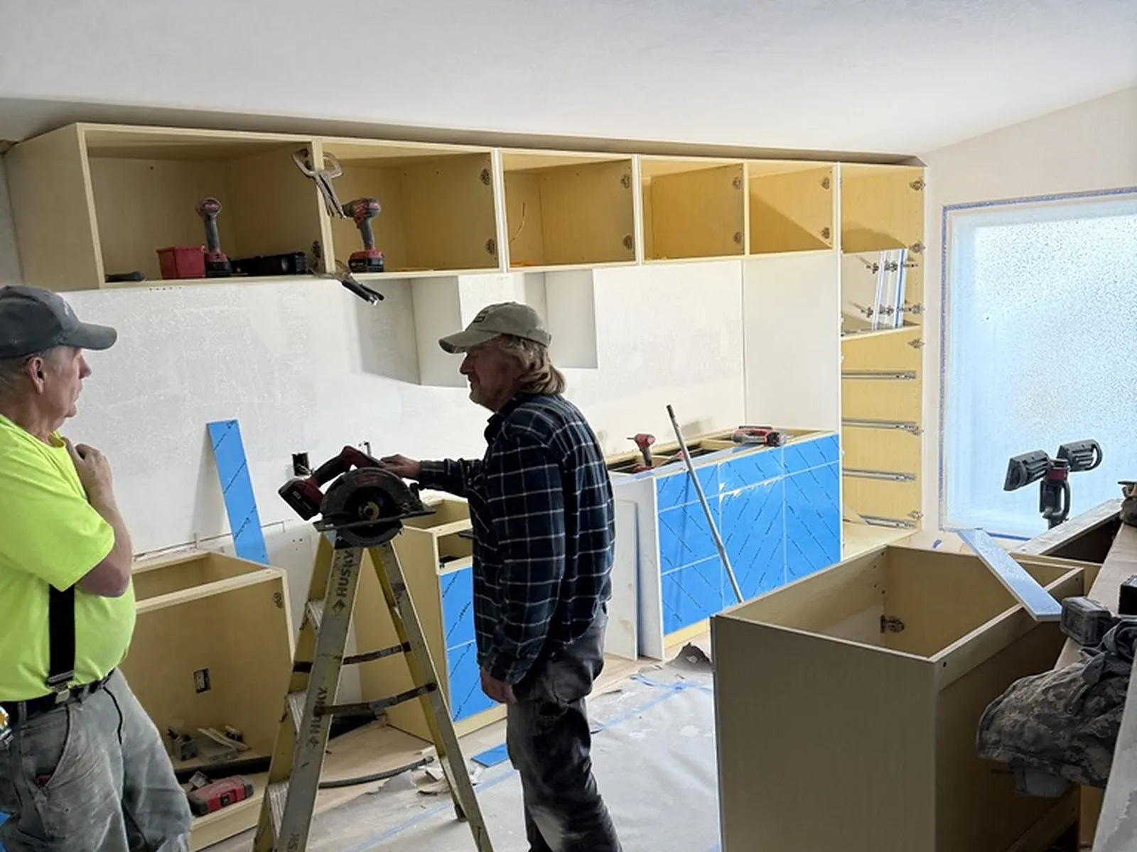 Two All Home HX crew members fitting the new kitchen cabinets