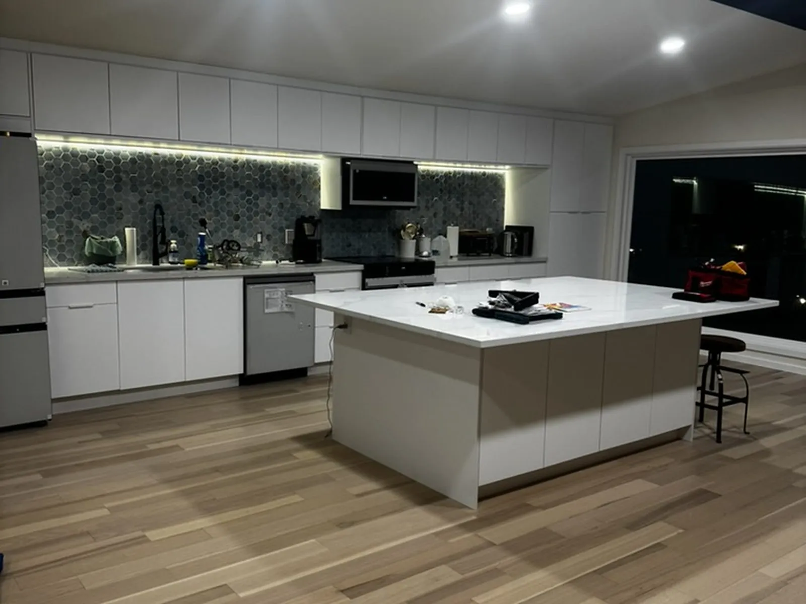 The finished kitchen, showing the tiled backsplash, range and island seating